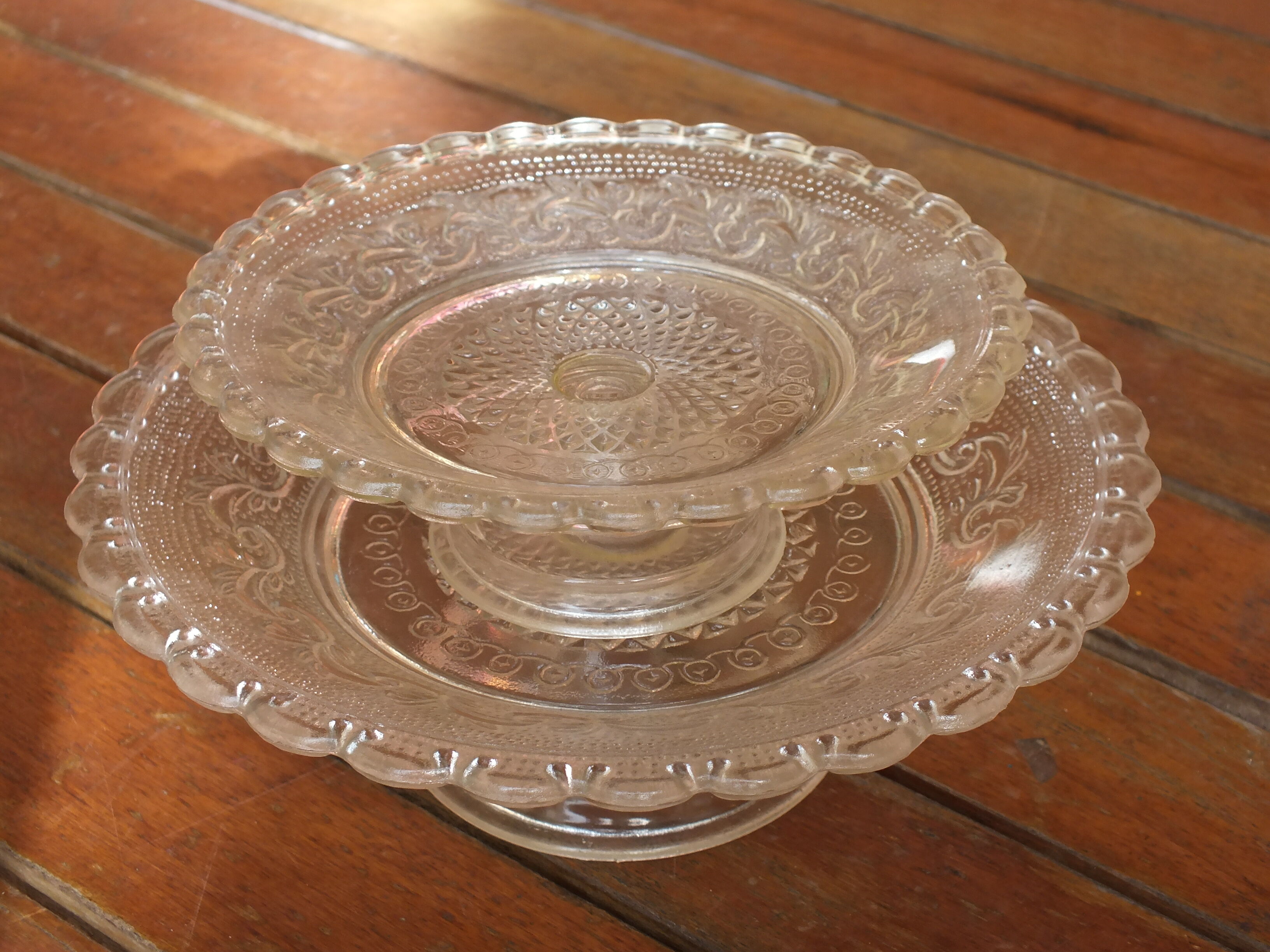 Duo of molded glass display cups, arabesque décor