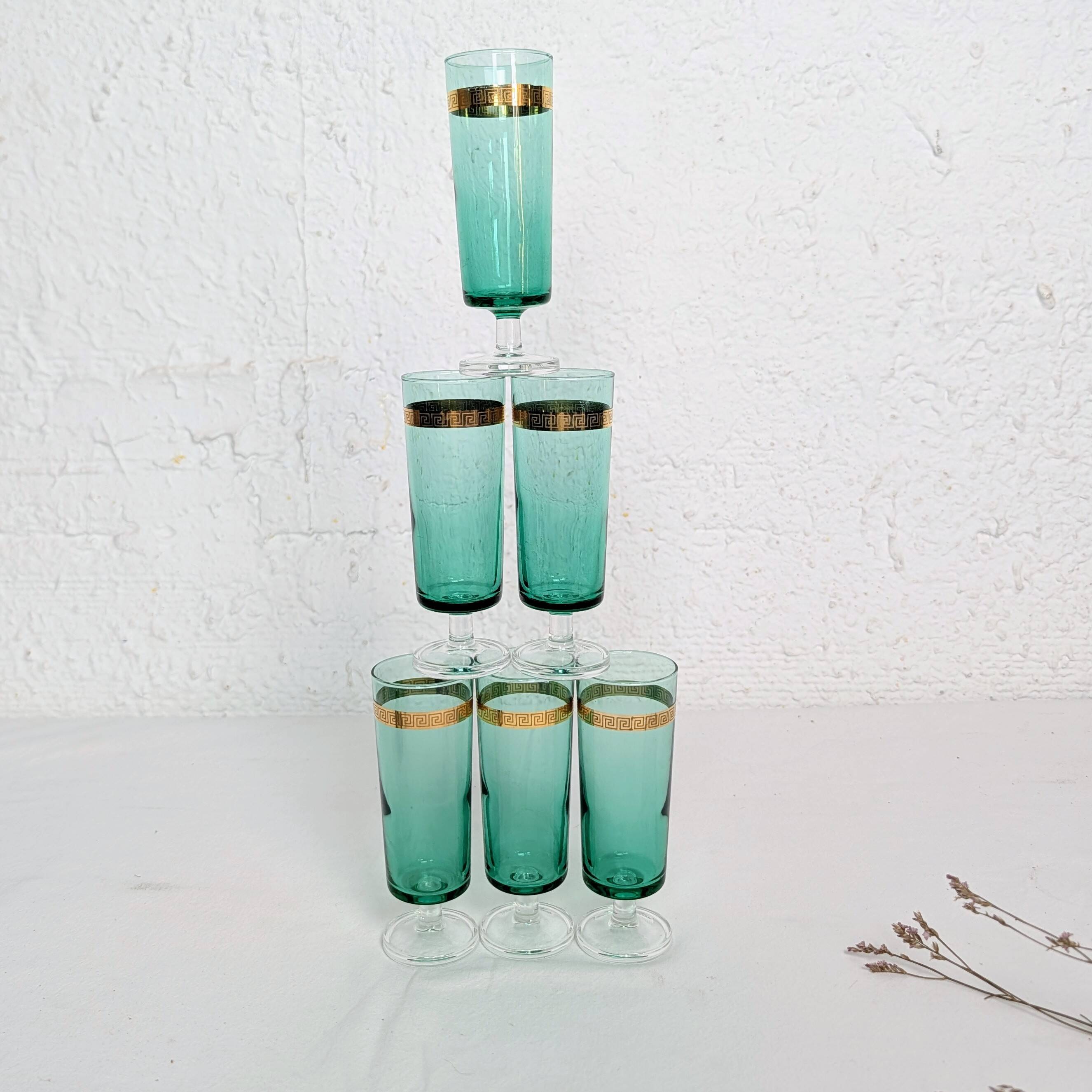 Set of 6 green champagne flutes with a golden rim.