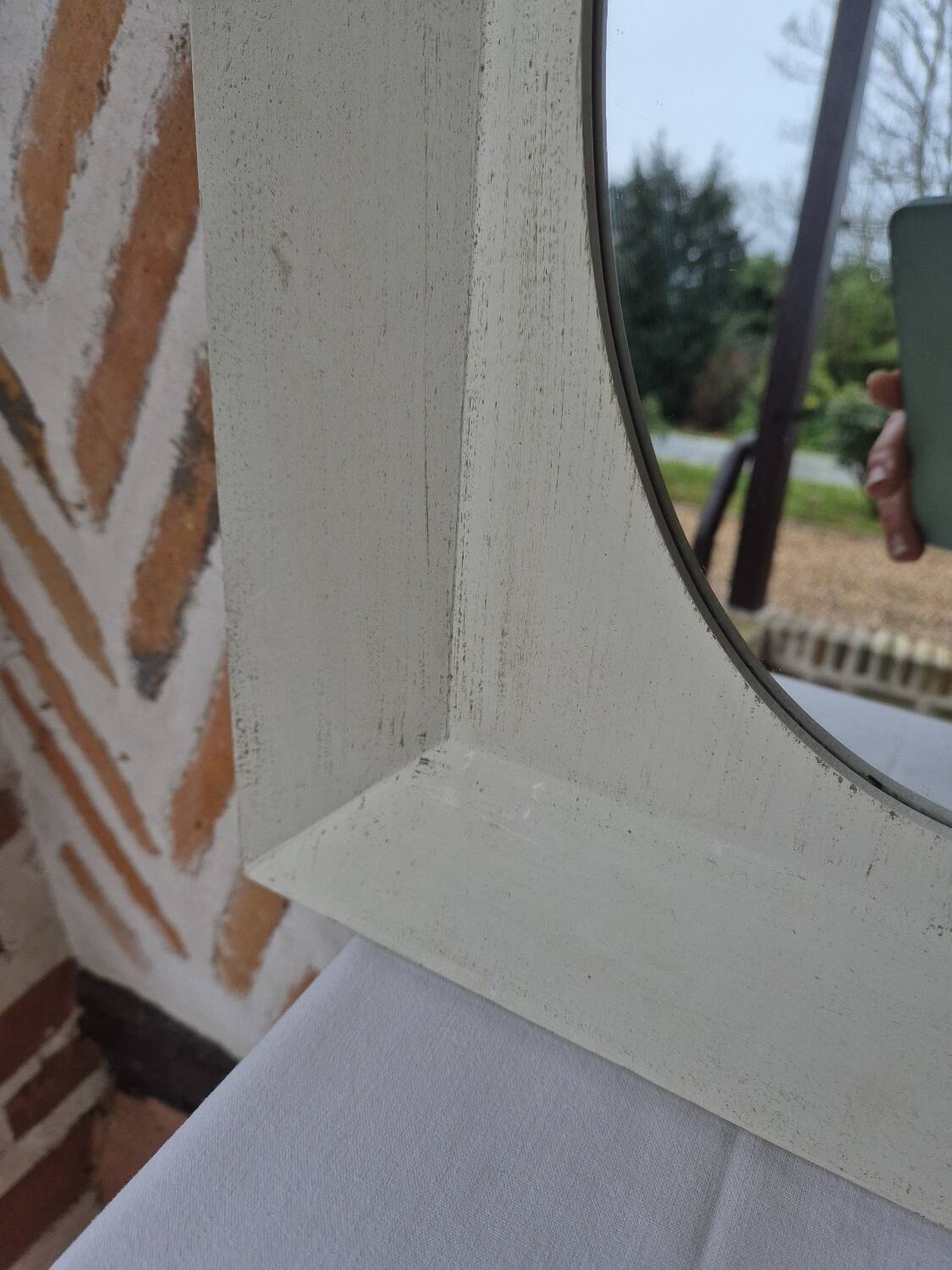 Oval mirror with a distressed white frame