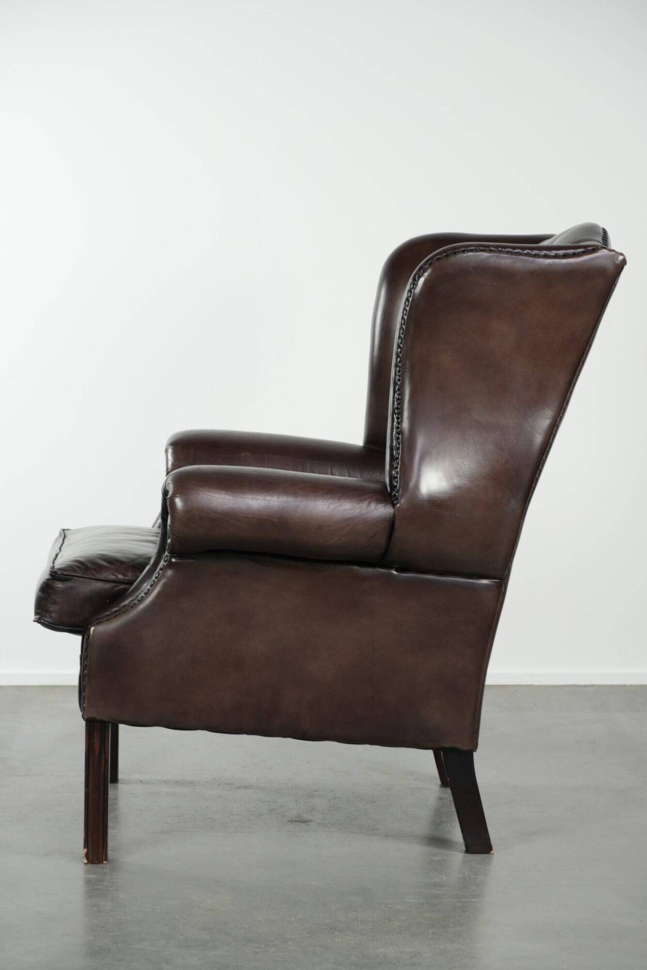 Dark brown cowhide Chesterfield wingback armchair in classic English style