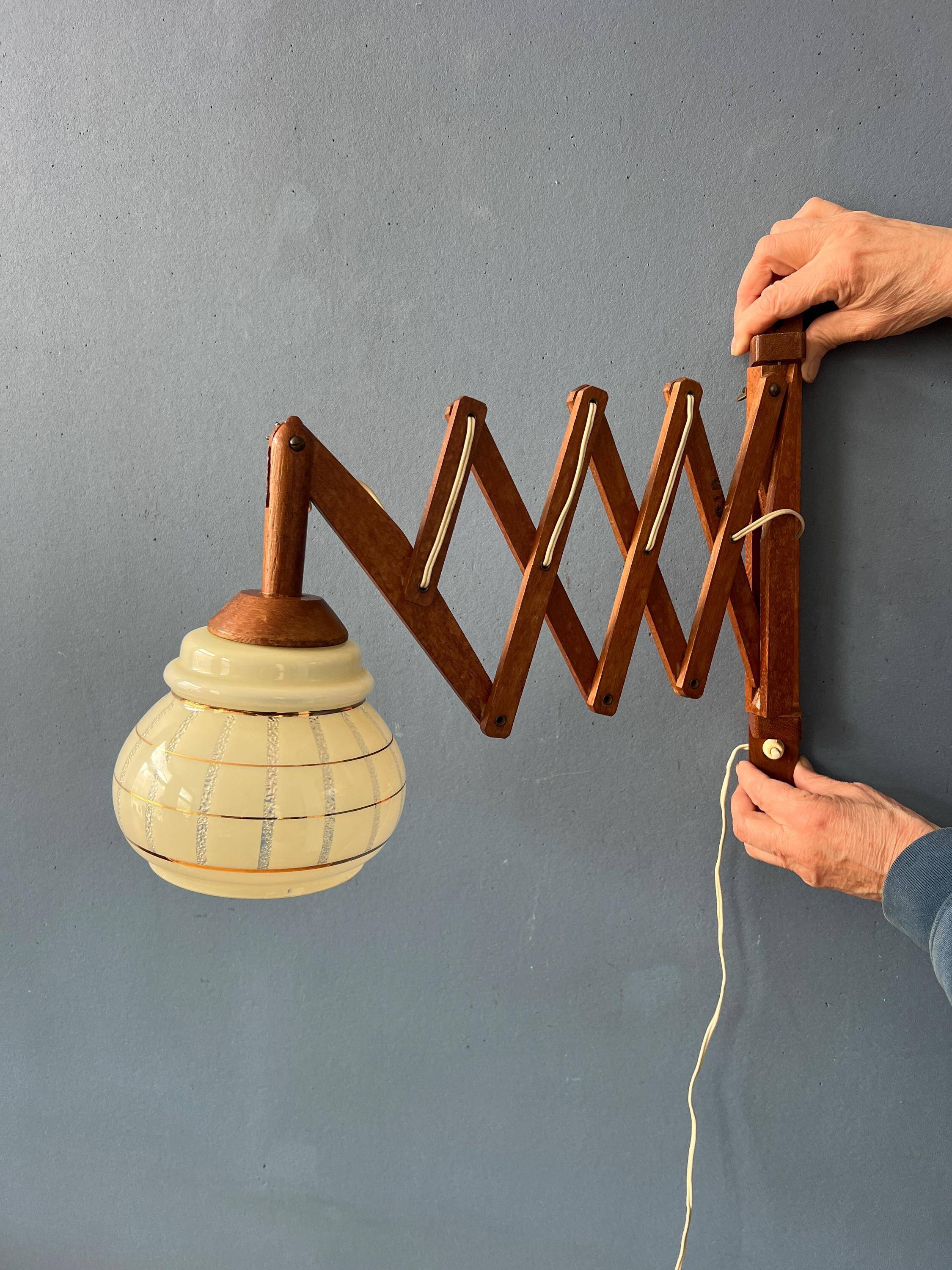 Vintage wall lamp with teak wood scissors and glass shade.