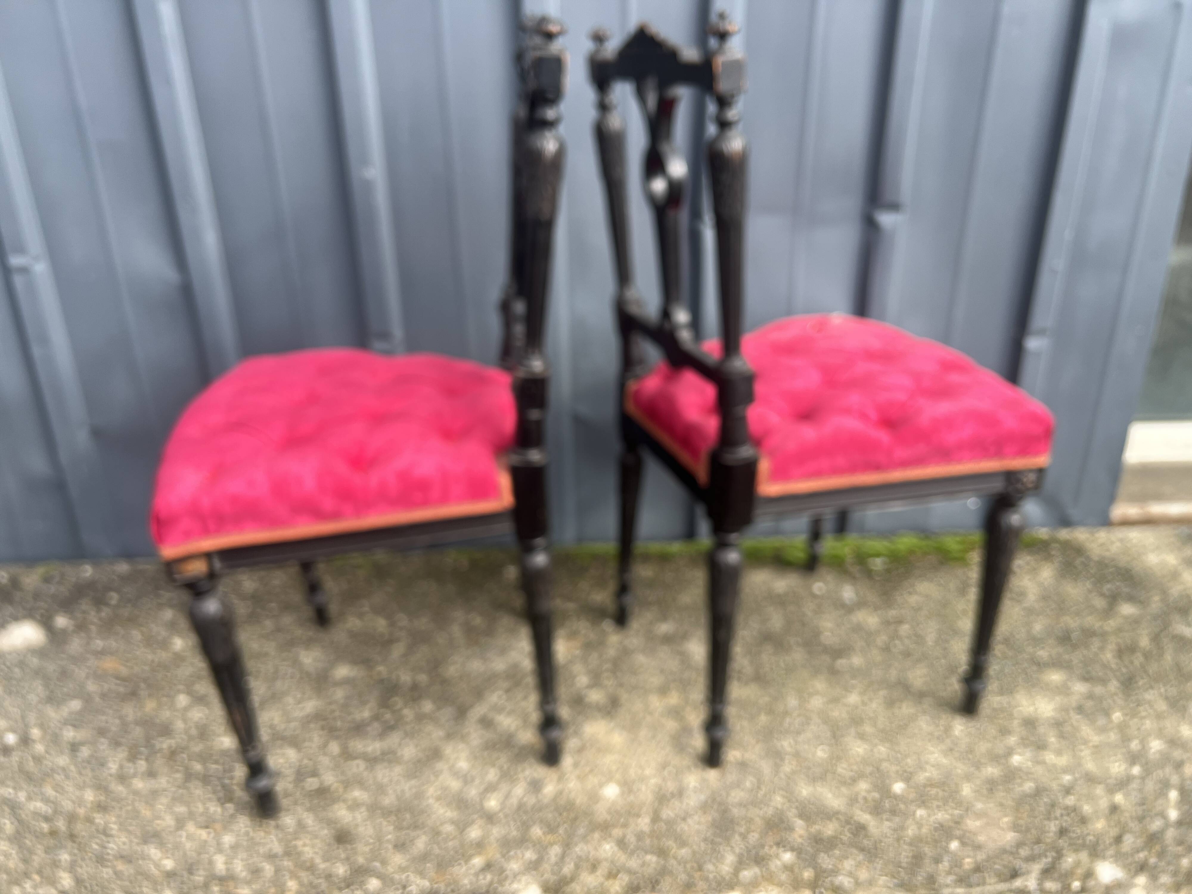 Pair of black lacquered chairs with purple tufted upholstery.