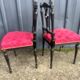 Pair of black lacquered chairs with purple tufted upholstery.