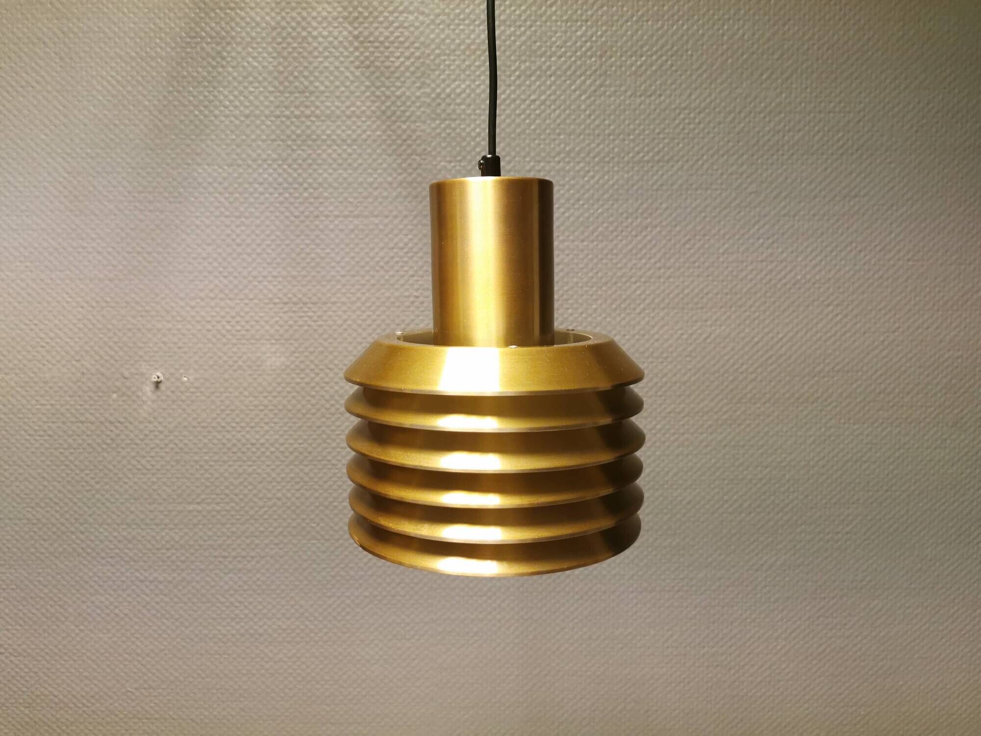 Hanging lamp in gold-colored aluminum with many layers of shades.