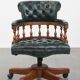 Dark green leather Chesterfield office chair on wheels.