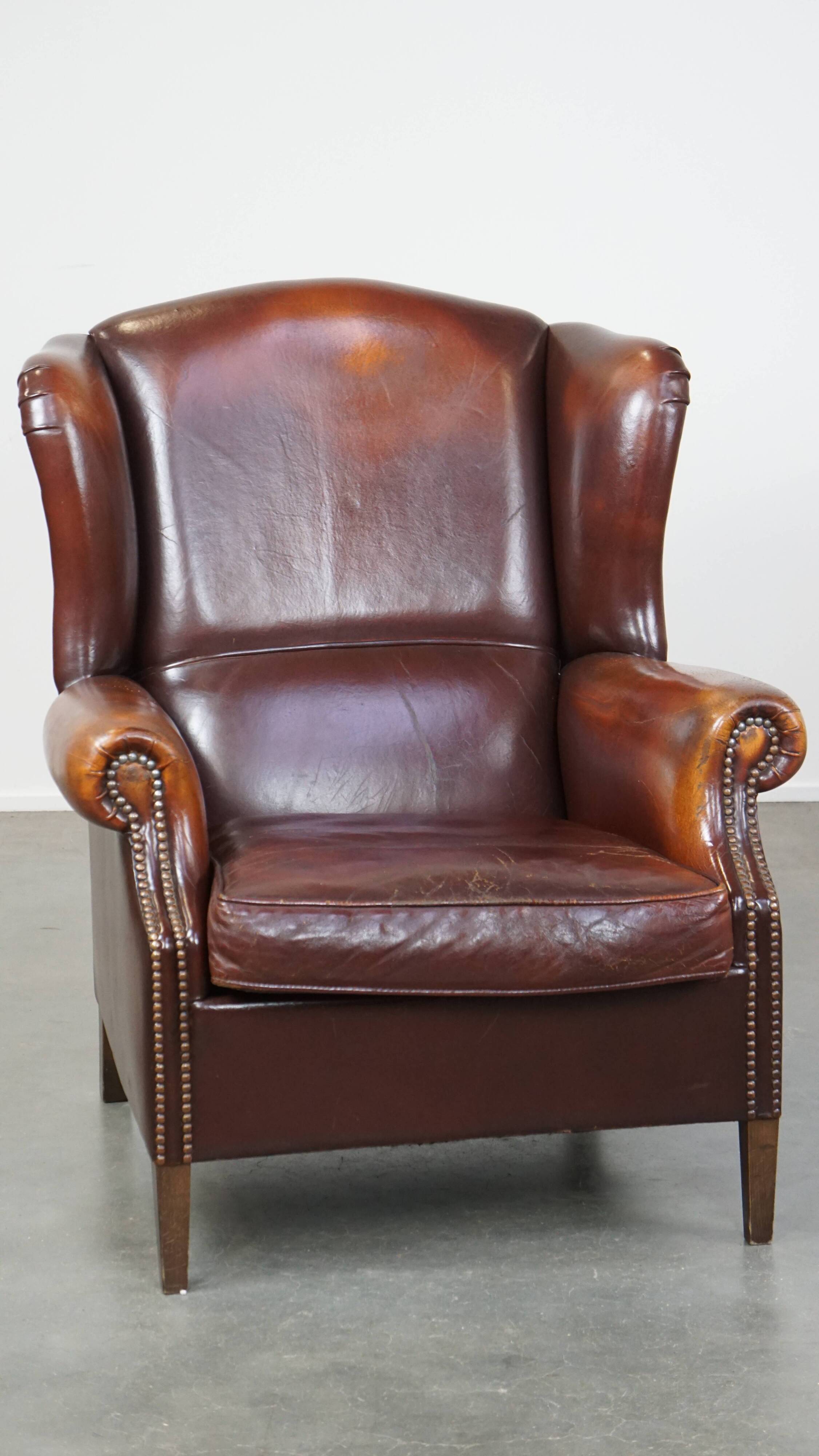 Dark English style sheepskin wingback chair with character and patina