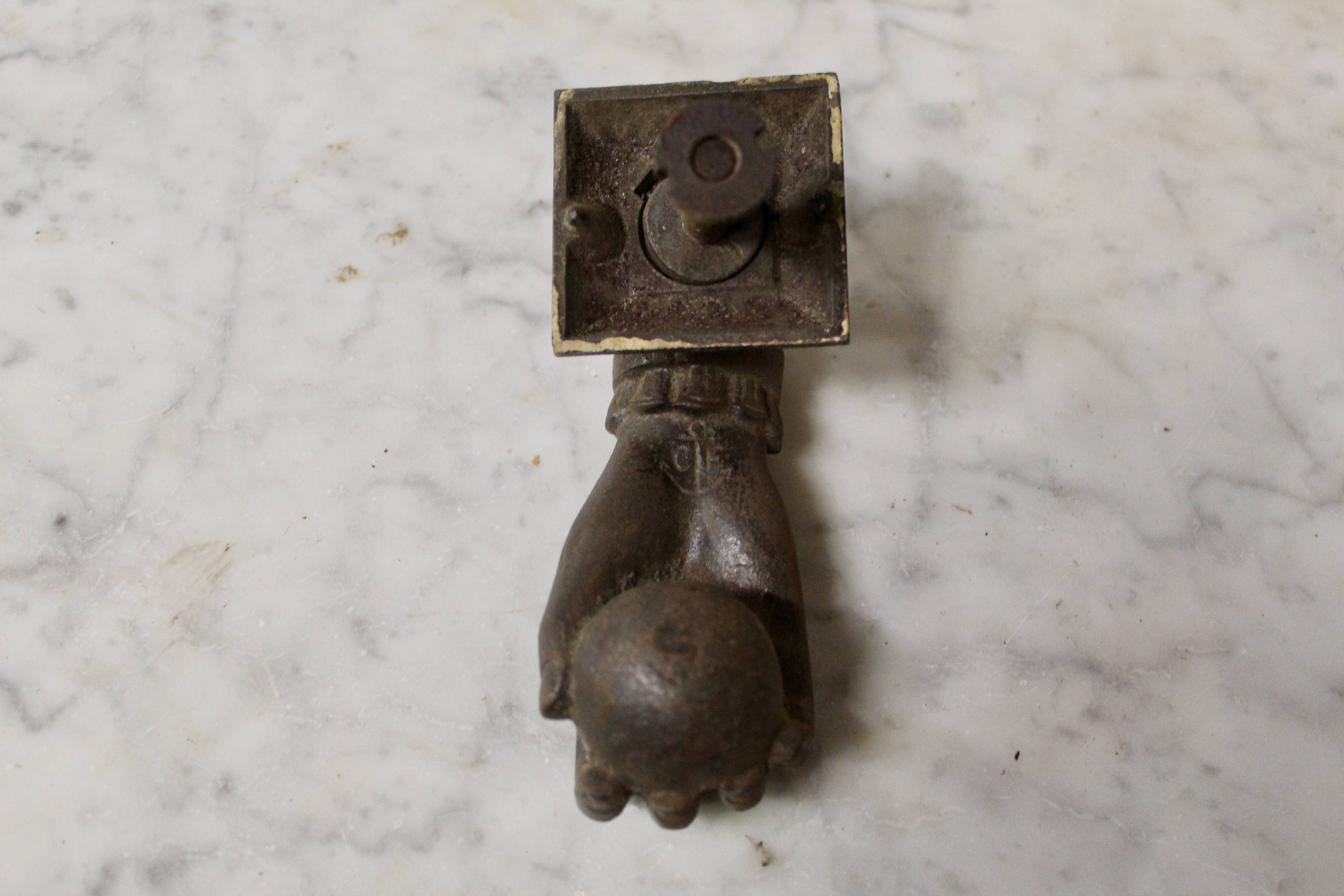 Antique cast iron door knocker in the shape of a 19th century hand