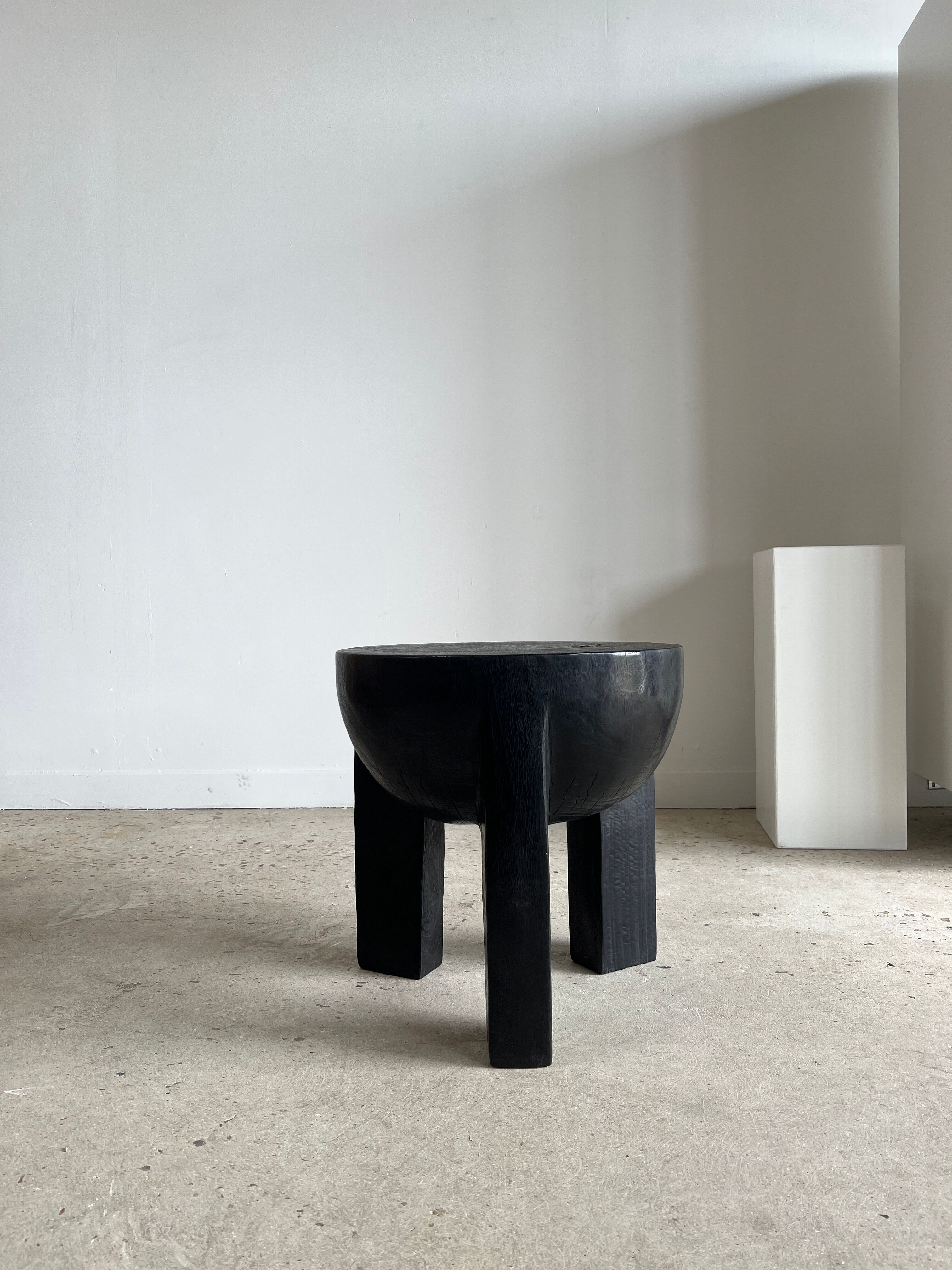 Black mango wood tripod side table with a semi-spherical top, height: 45 cm, diameter: 44 cm.