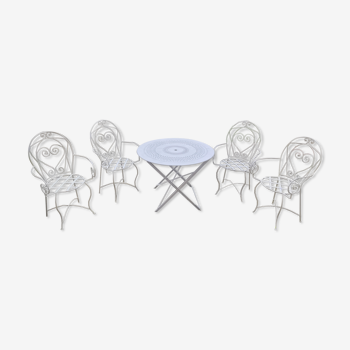 Folding round table and four wrought iron armchairs