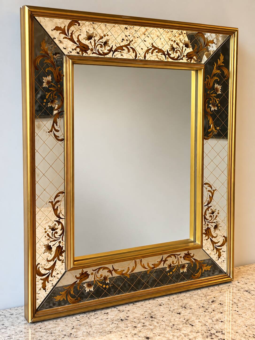 Large Venetian-style mirror with golden floral decoration.