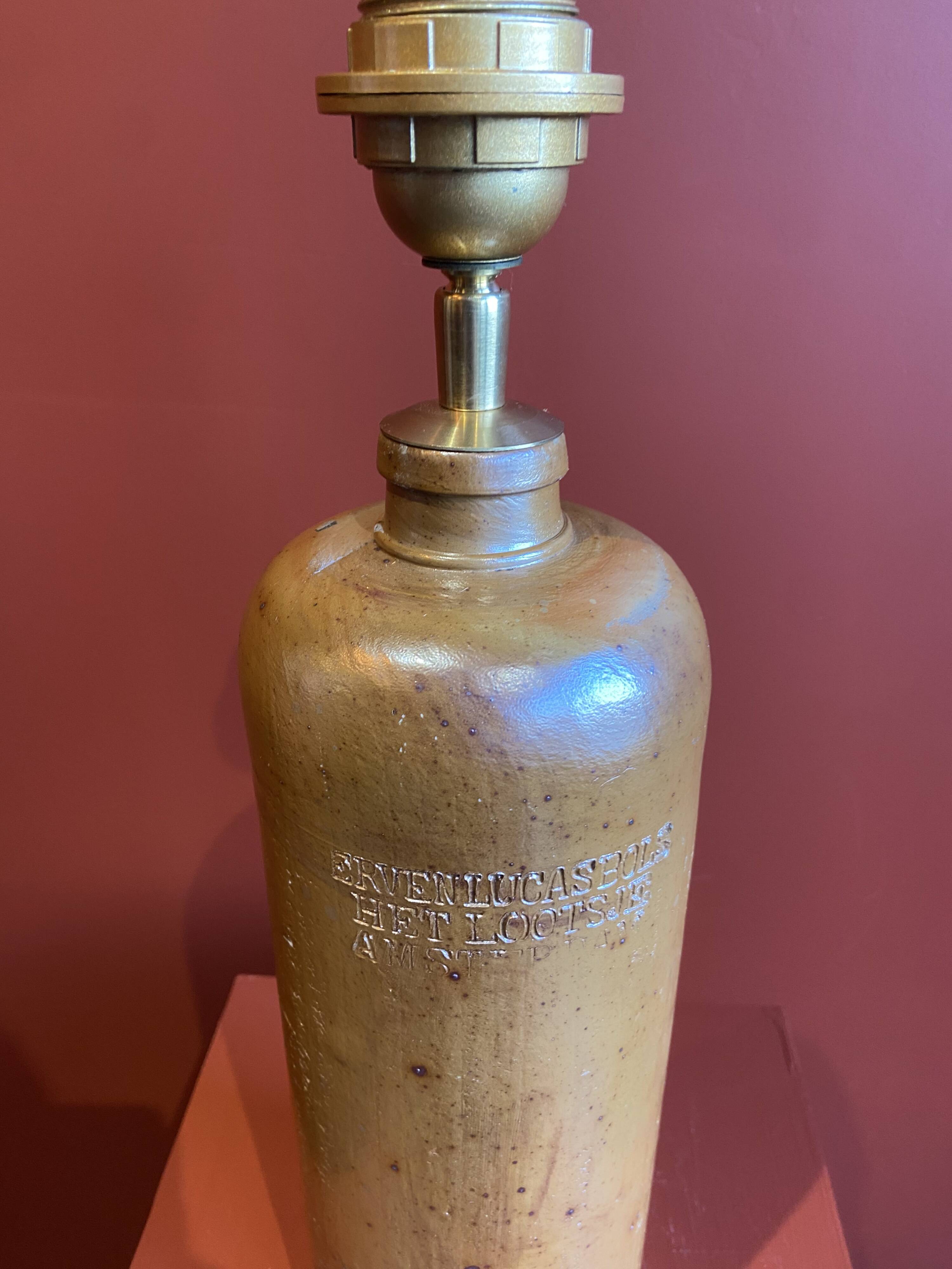"Stoneware Bottle Lamp" with a multicoloured blue lampshade handwoven in India.