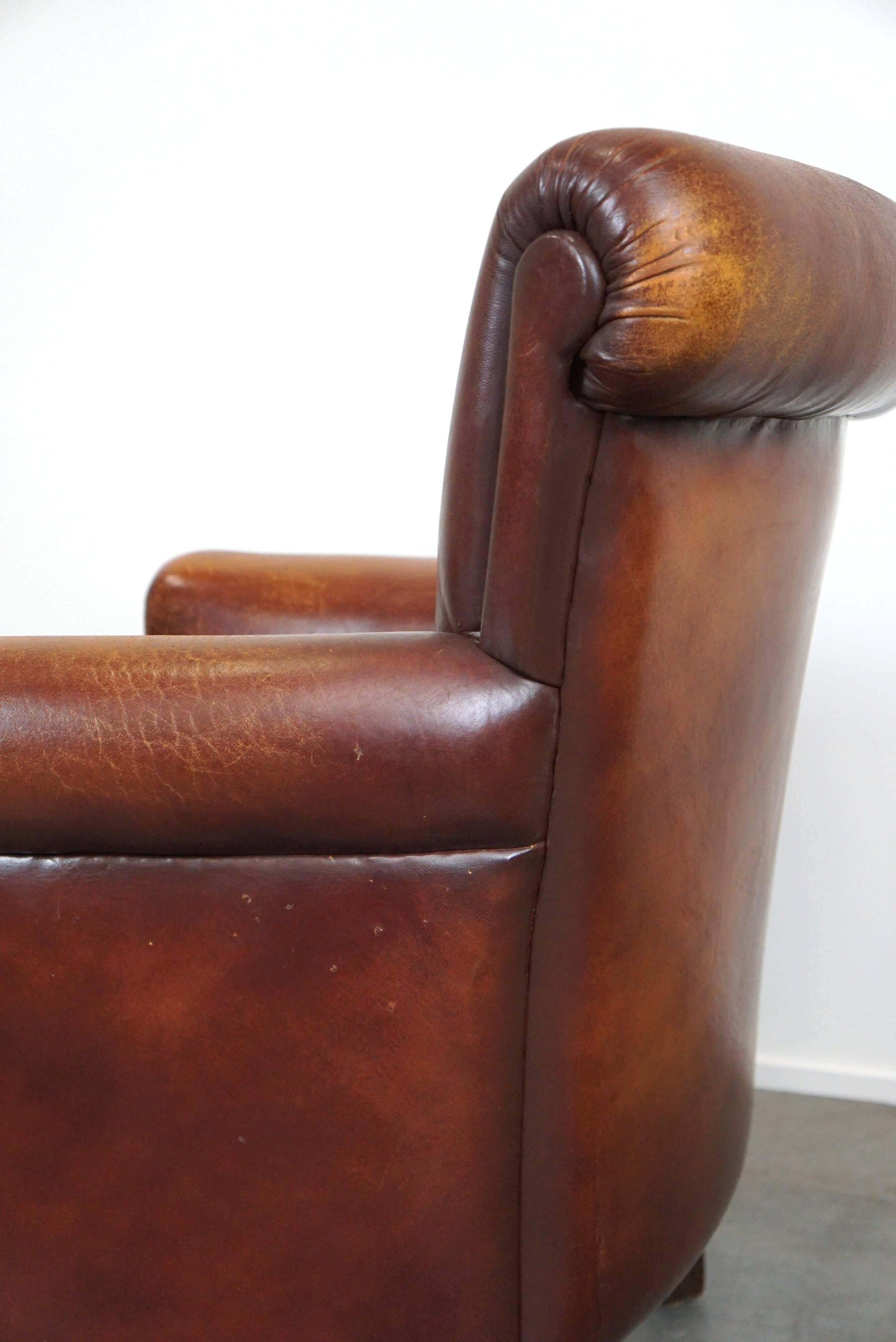 Fauteuil en cuir de mouton robuste et usé mais très confortable avec une belle patine
