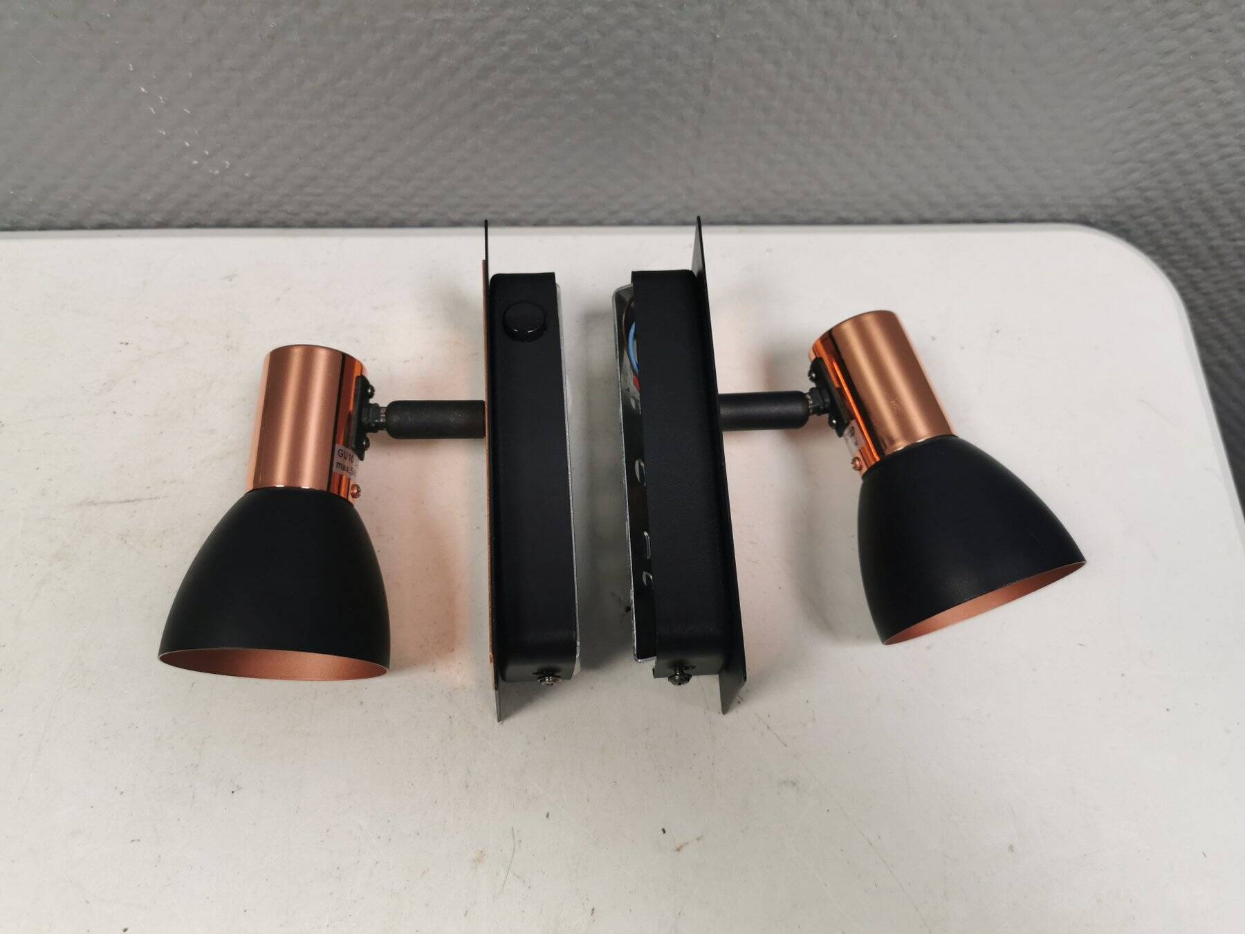 A pair of wall lamps from Eglo, in copper color and black.