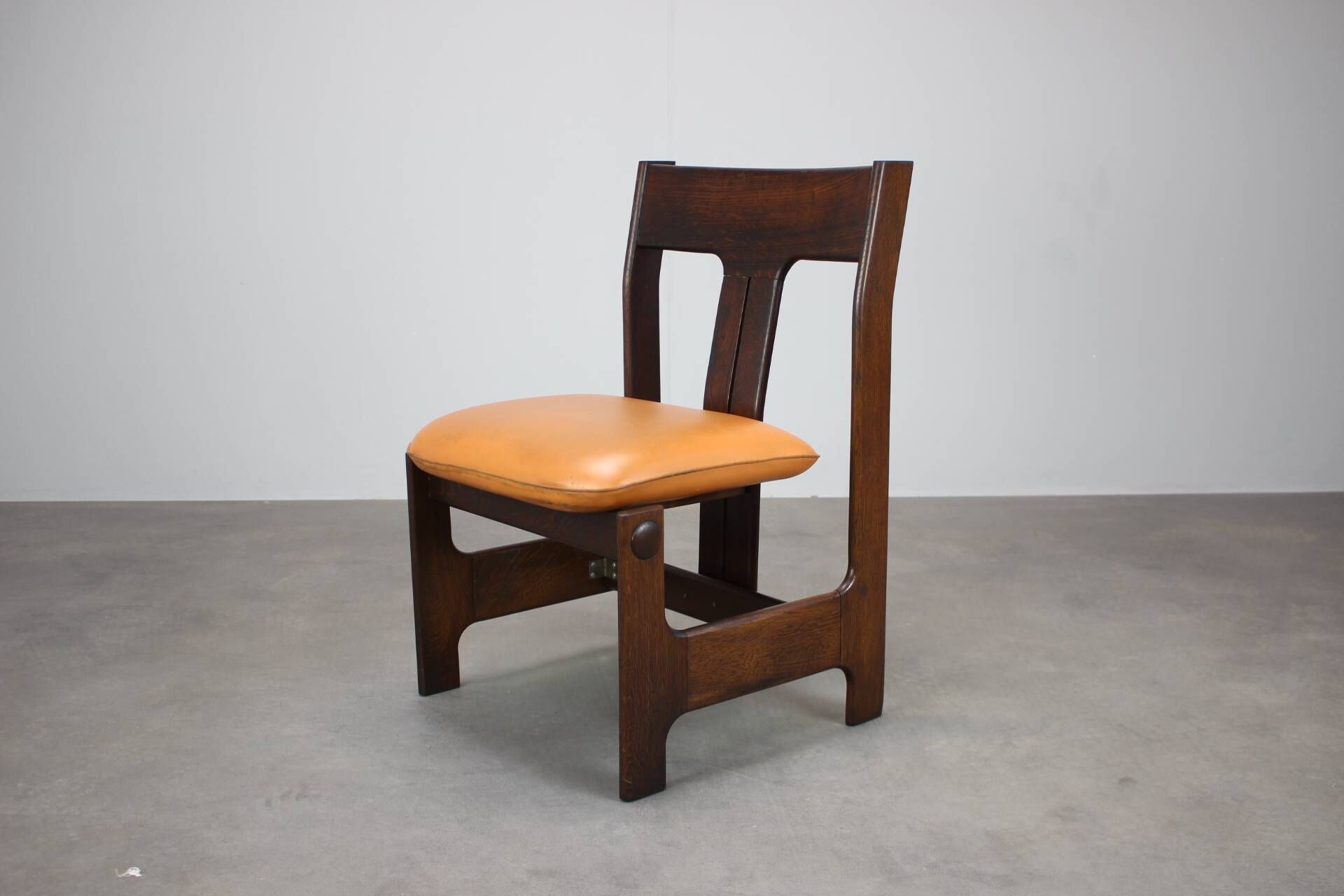 Vintage German sculptural chair from the 1970s in wood with orange faux leather.