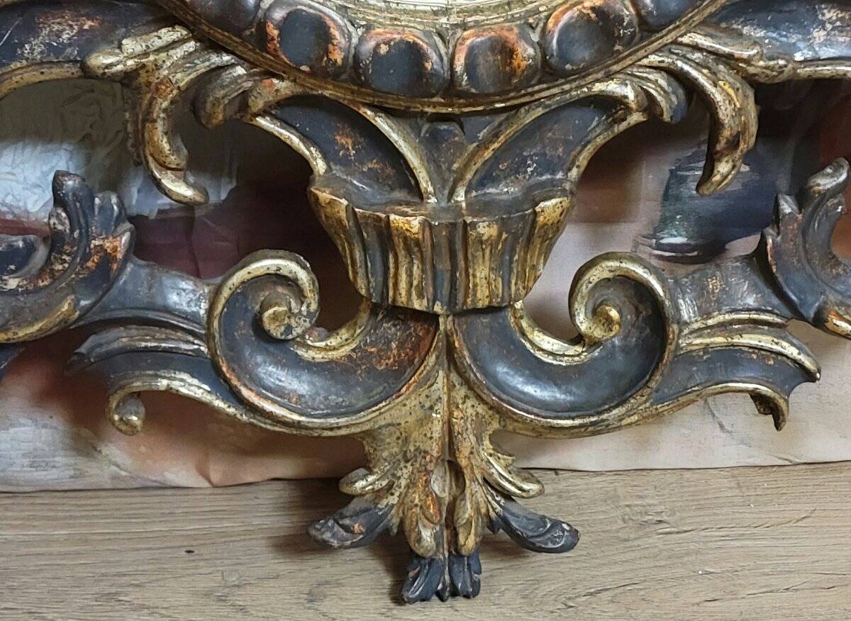 Antique Louis XV style mirror, richly carved with decorations of scrolls, shells, and foliage.