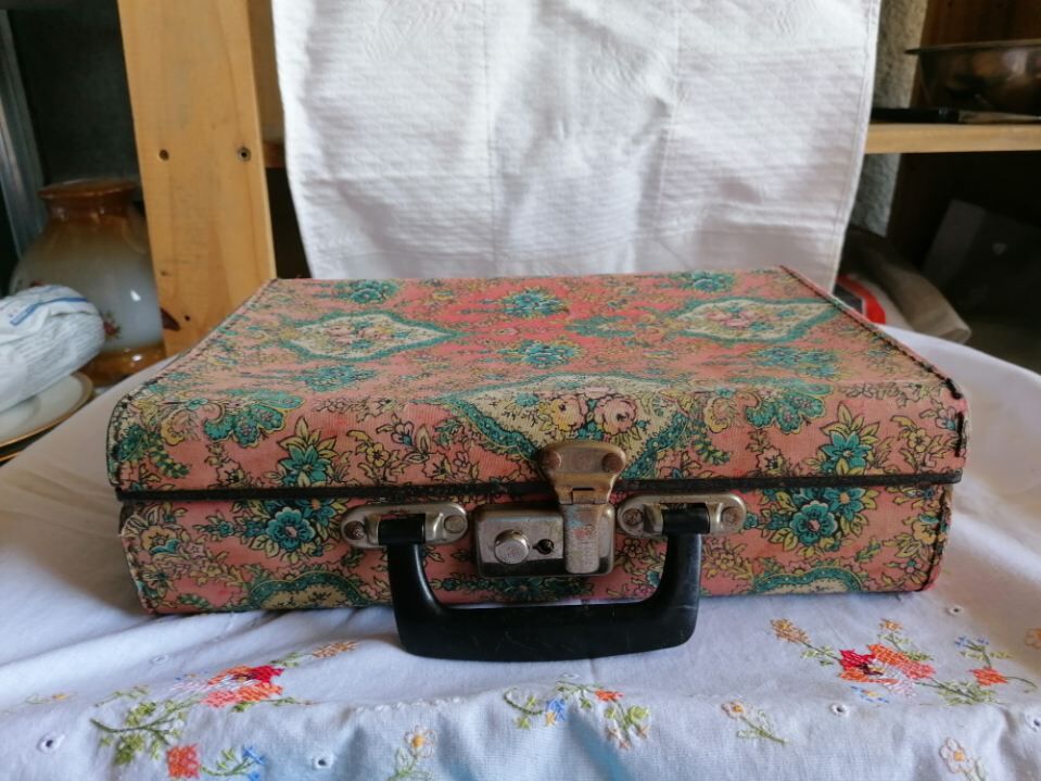 Old suitcase, red cashmere fabric, bohemian folk