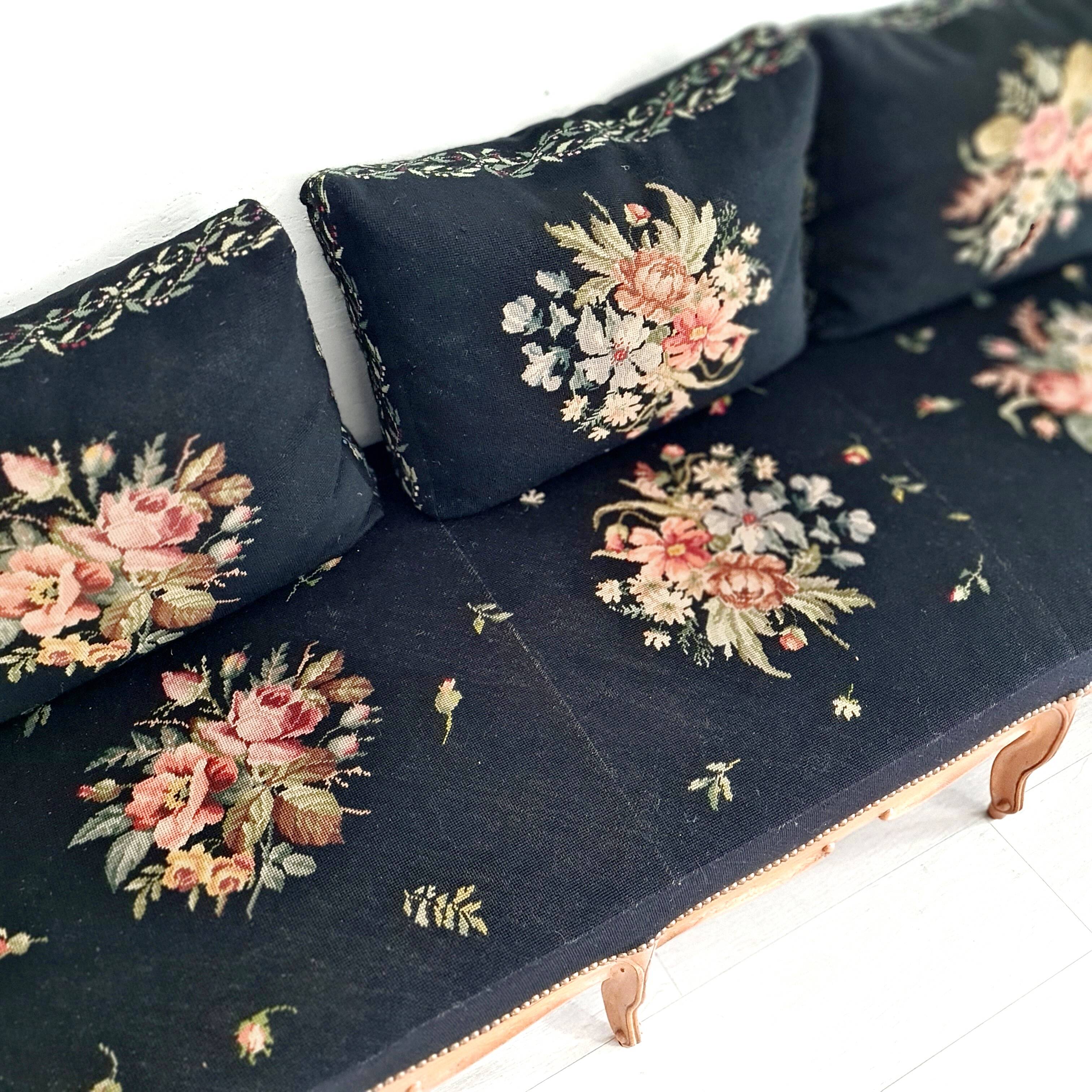 Old bench upholstered in black canvas flowers