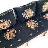 Old bench upholstered in black canvas flowers