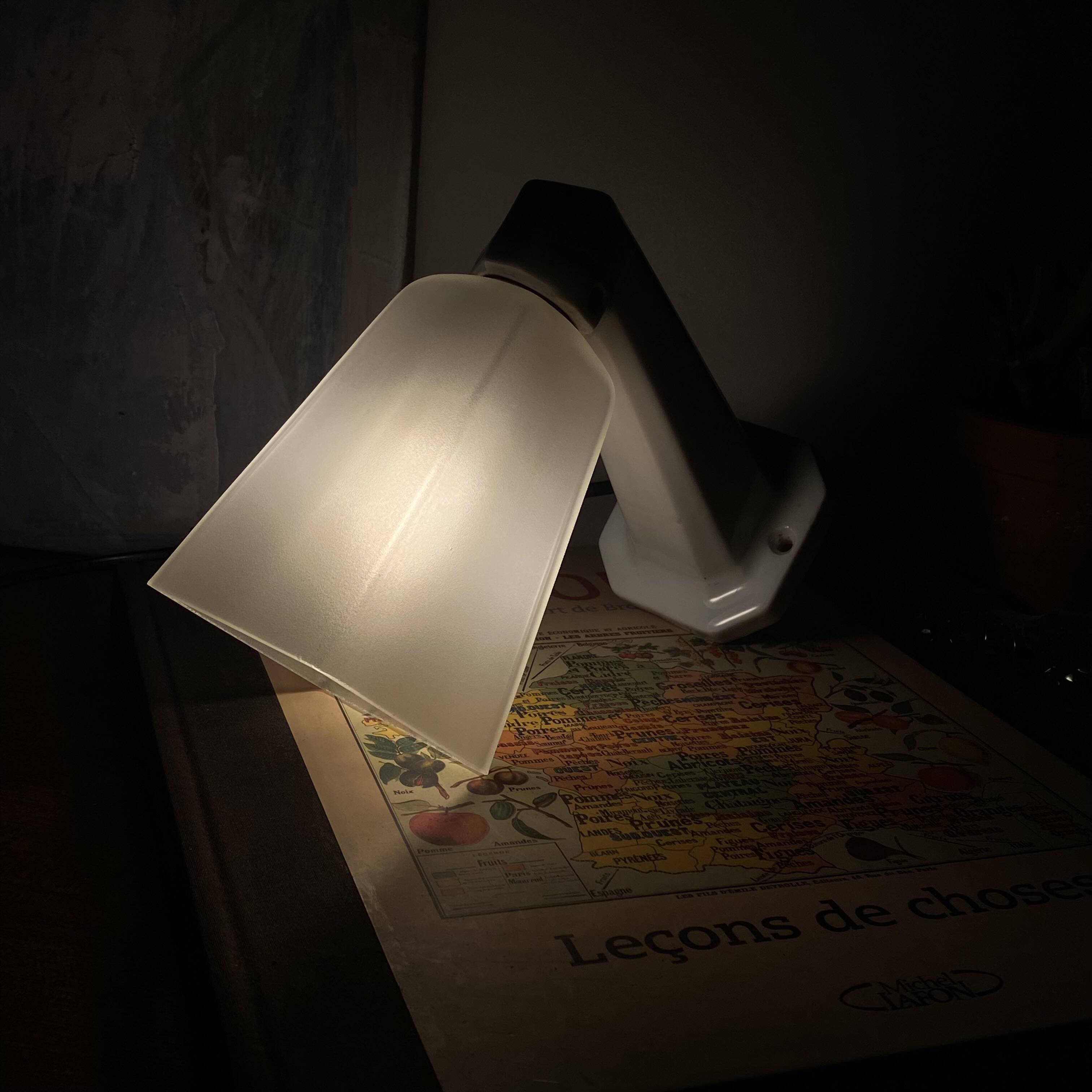 Swan neck wall light in ceramic with a translucent glass globe.