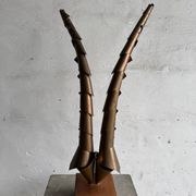 Golden brass sculptural horns on wooden base — modern metal art sculpture, 68.5 cm high
