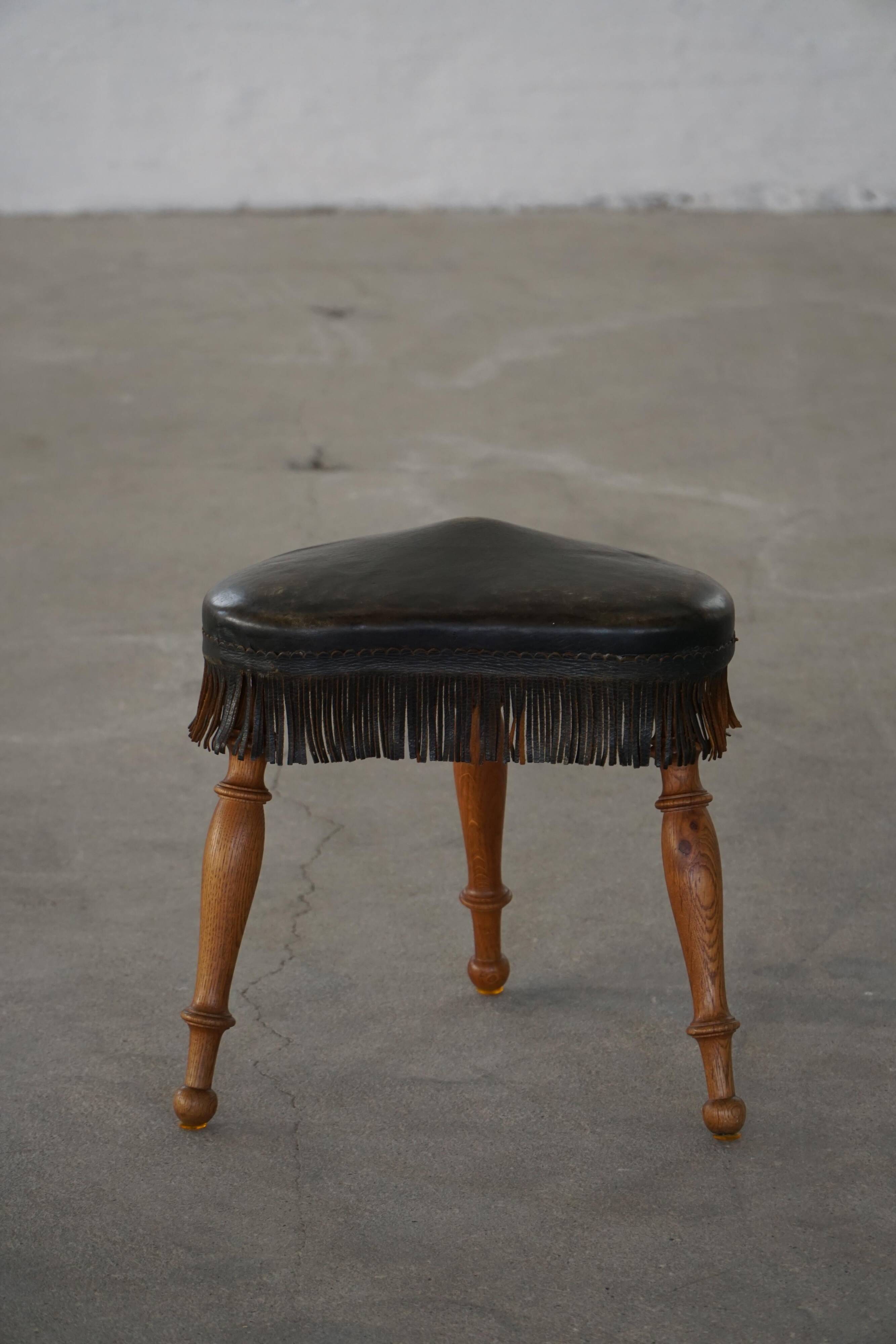 Danish oak tripod stool from the early 20th century with leather fringe, 1930s.