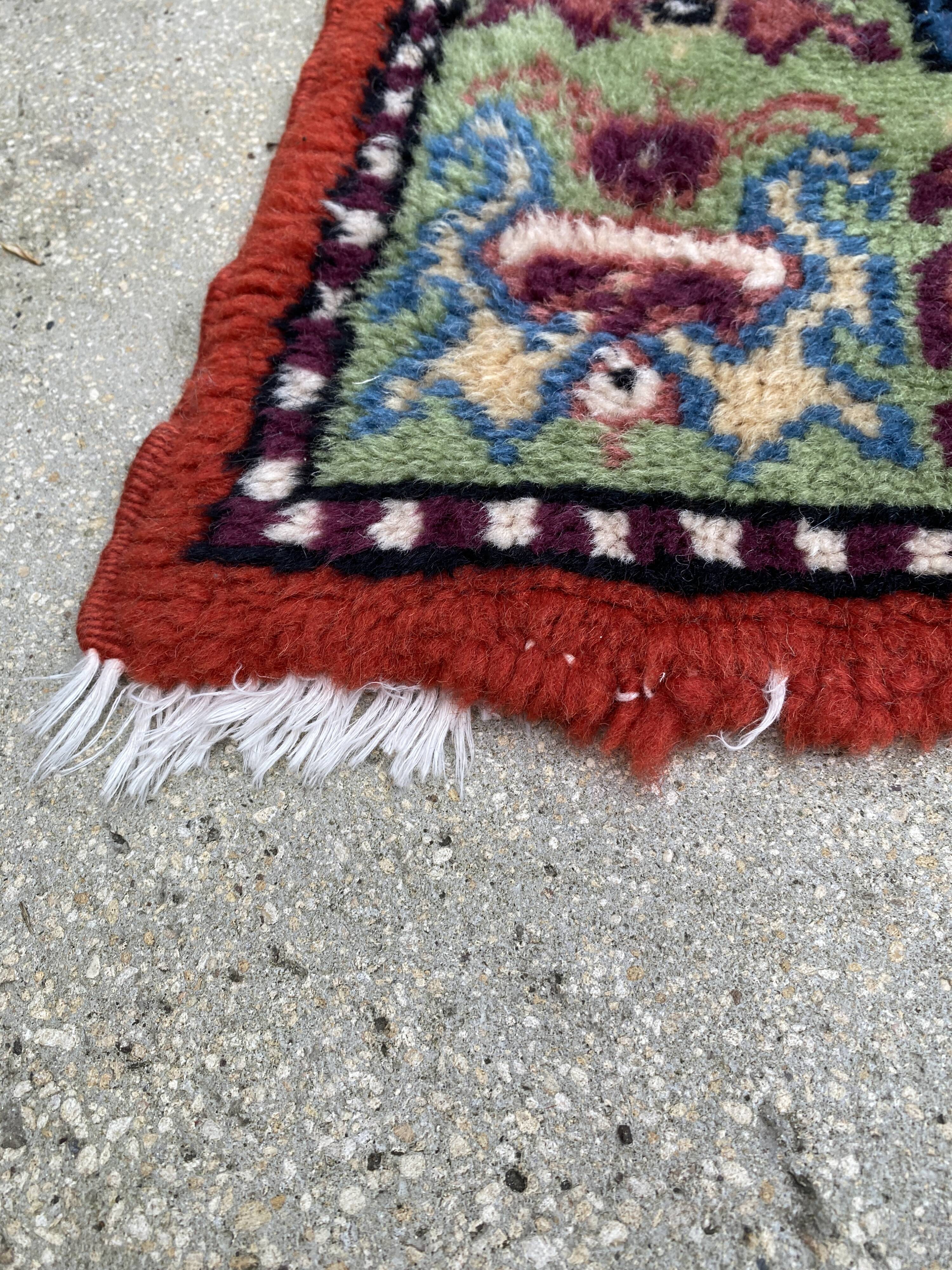 Vintage hand-knotted wool rug with polychrome decoration on a red, blue, green background 150 x 63 cm