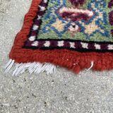 Vintage hand-knotted wool rug with polychrome decoration on a red, blue, green background 150 x 63 cm