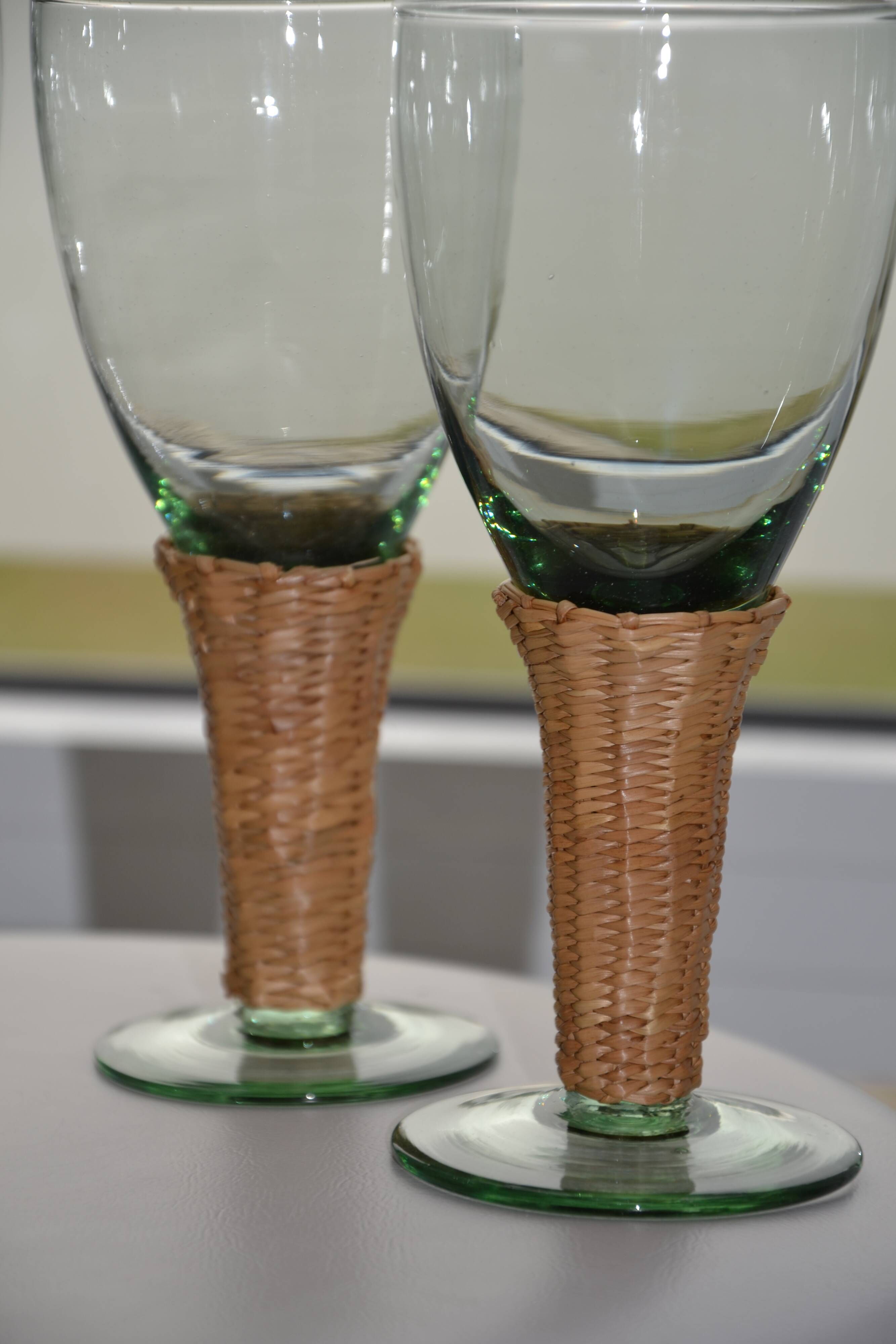 Four stemmed glasses surrounded by rattan.