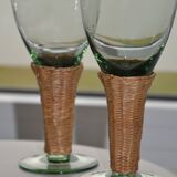 Four stemmed glasses surrounded by rattan.