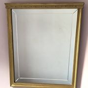 Miroir en bois doré, de forme organique avec une glace biseauté