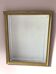 Golden wooden mirror, with an organic shape and bevelled glass.