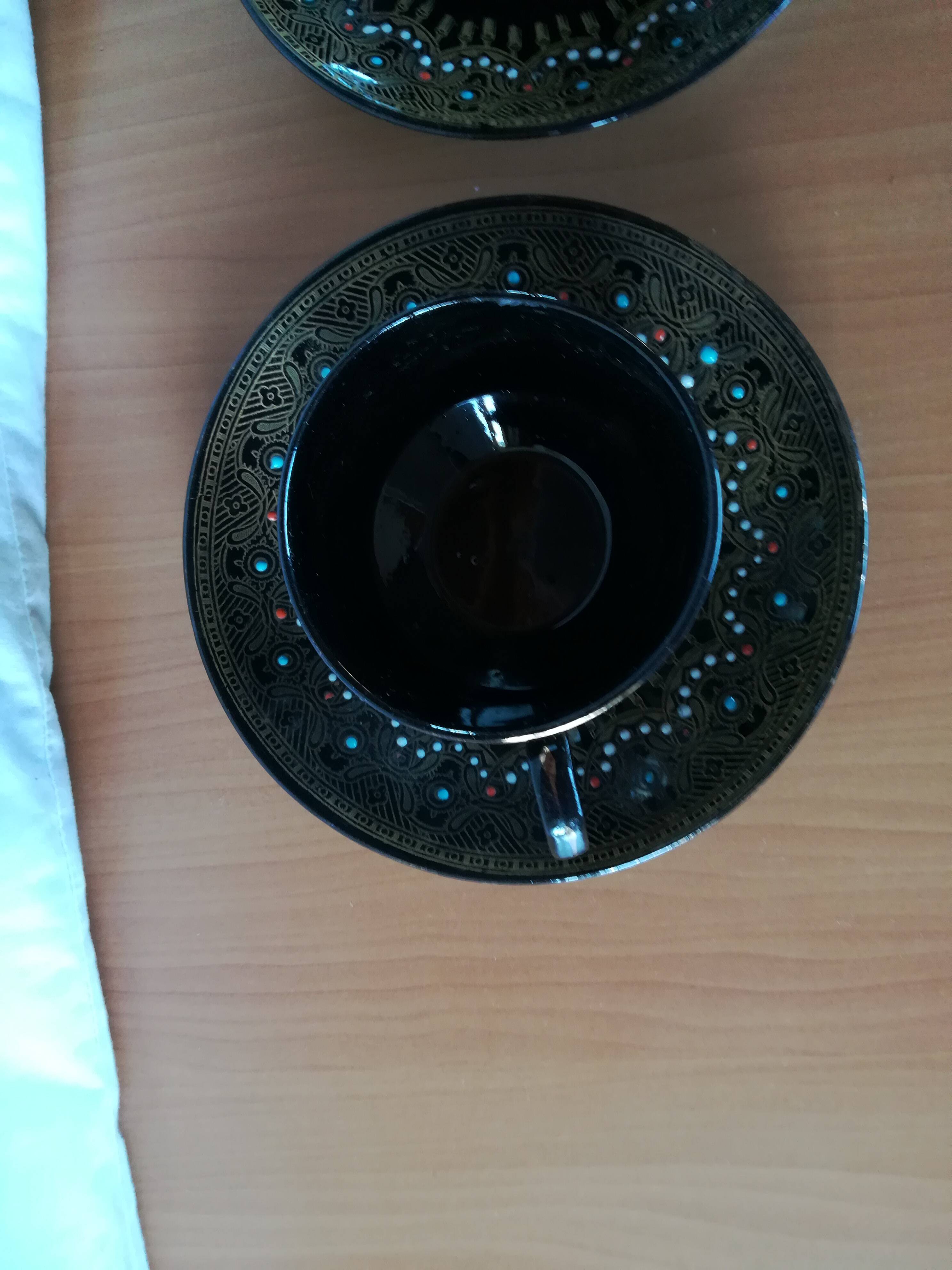 Black cups and saucers with relief decoration