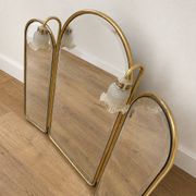 Vintage triptych mirror in brass with wall lights.