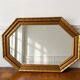 Octagonal gold mirror with copper reflections.