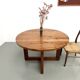 Modernist round table in solid elm, crossed legs.
