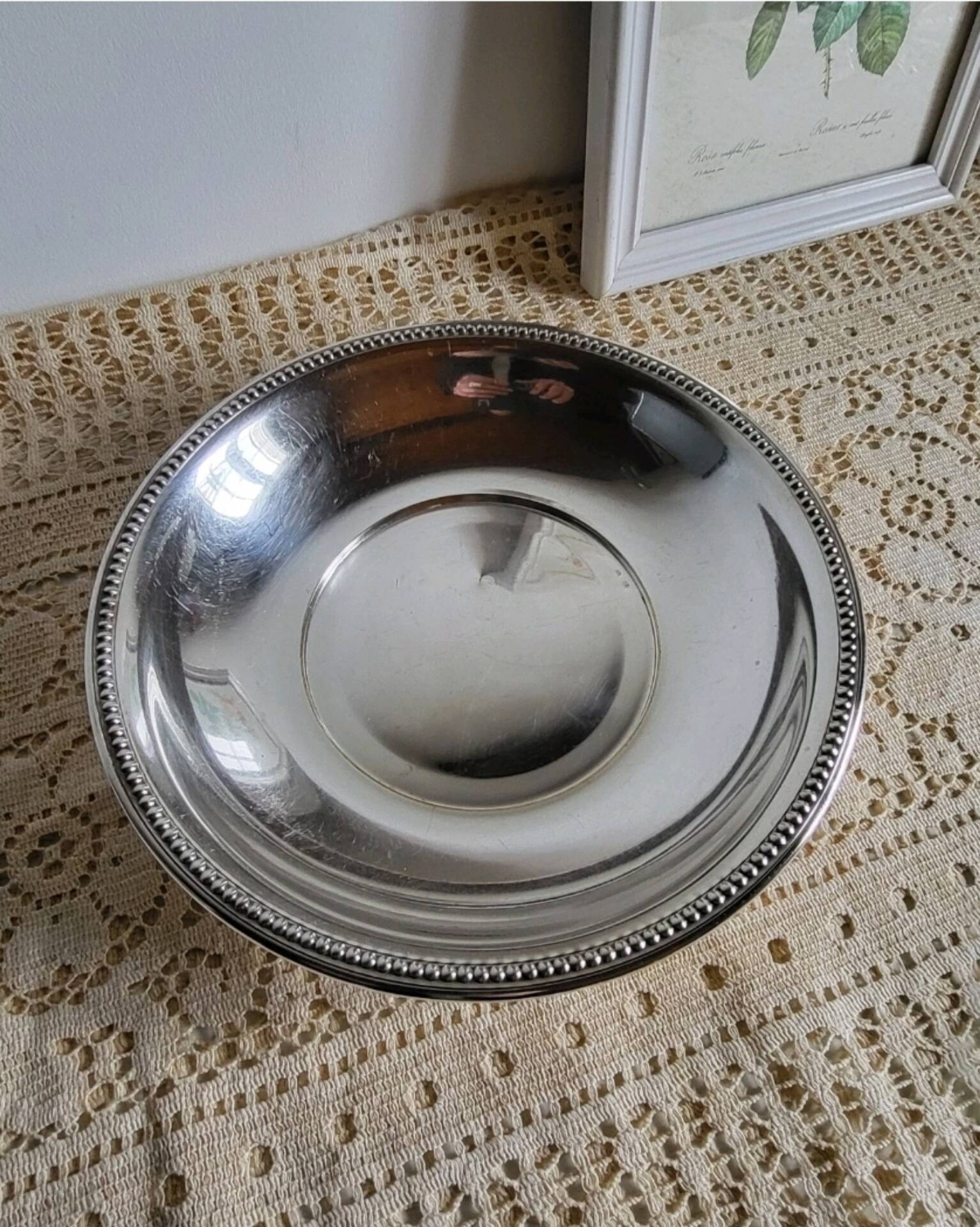 Shallow round metal plate with pearl row decoration.