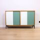 A vintage mid-century bookshelf/sideboard with green and white sliding door