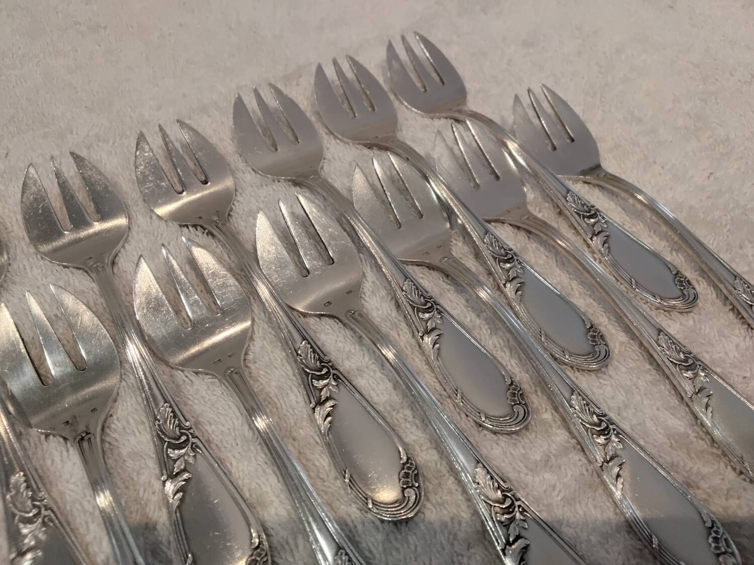 12 silver-plated oyster forks with rocaille ribbon decoration, 13.7 cm