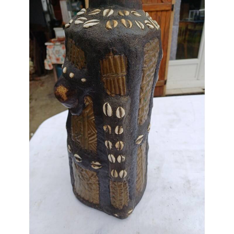 African statue of a woman, made of wood, brass, beads, and seashells.