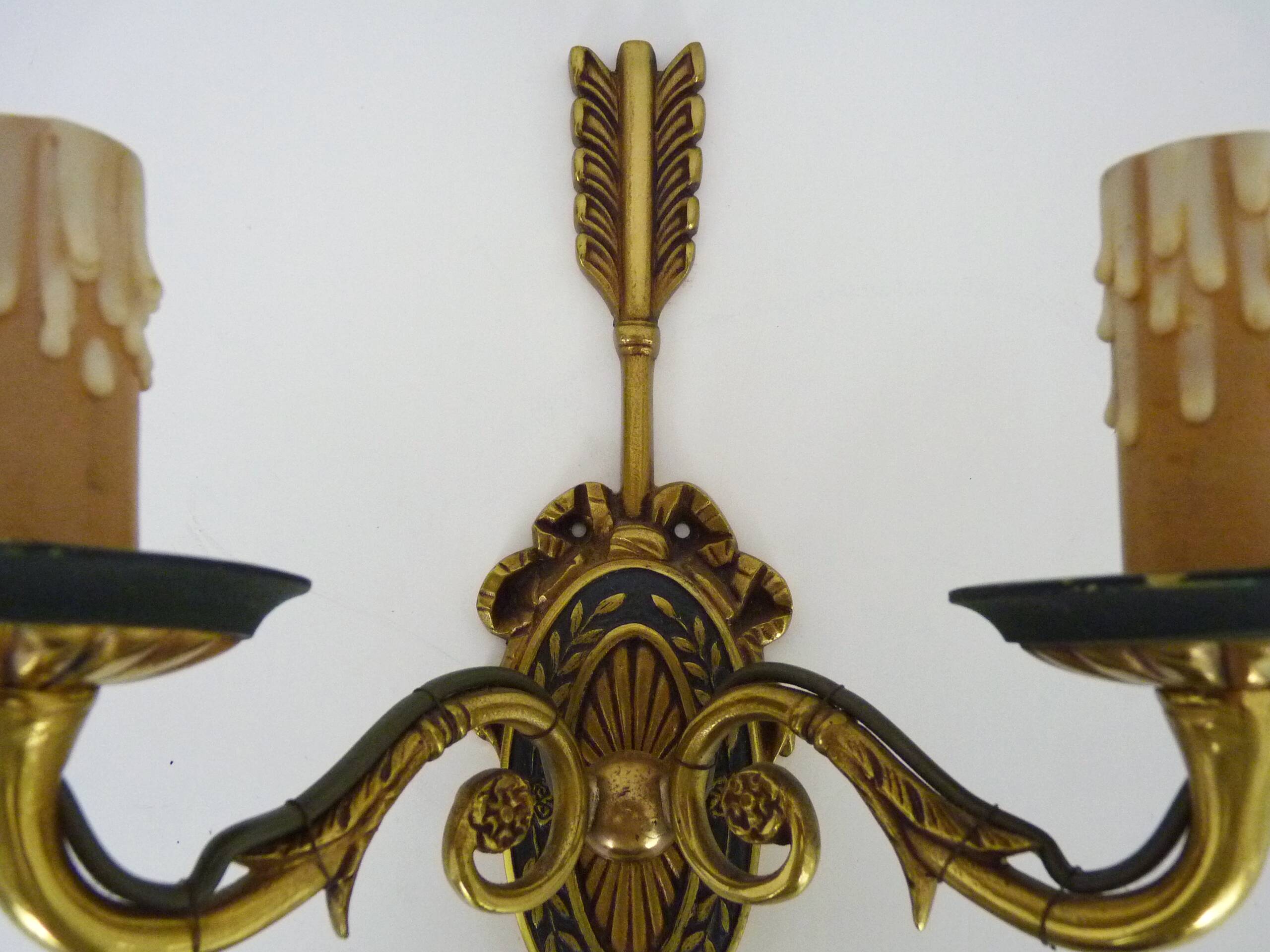 Pair of double-light Empire style arrow wall lights in bronze. Early 20th century