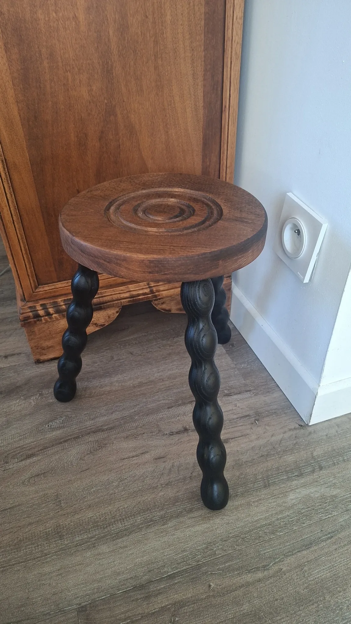 Brown and black wooden tripod stool