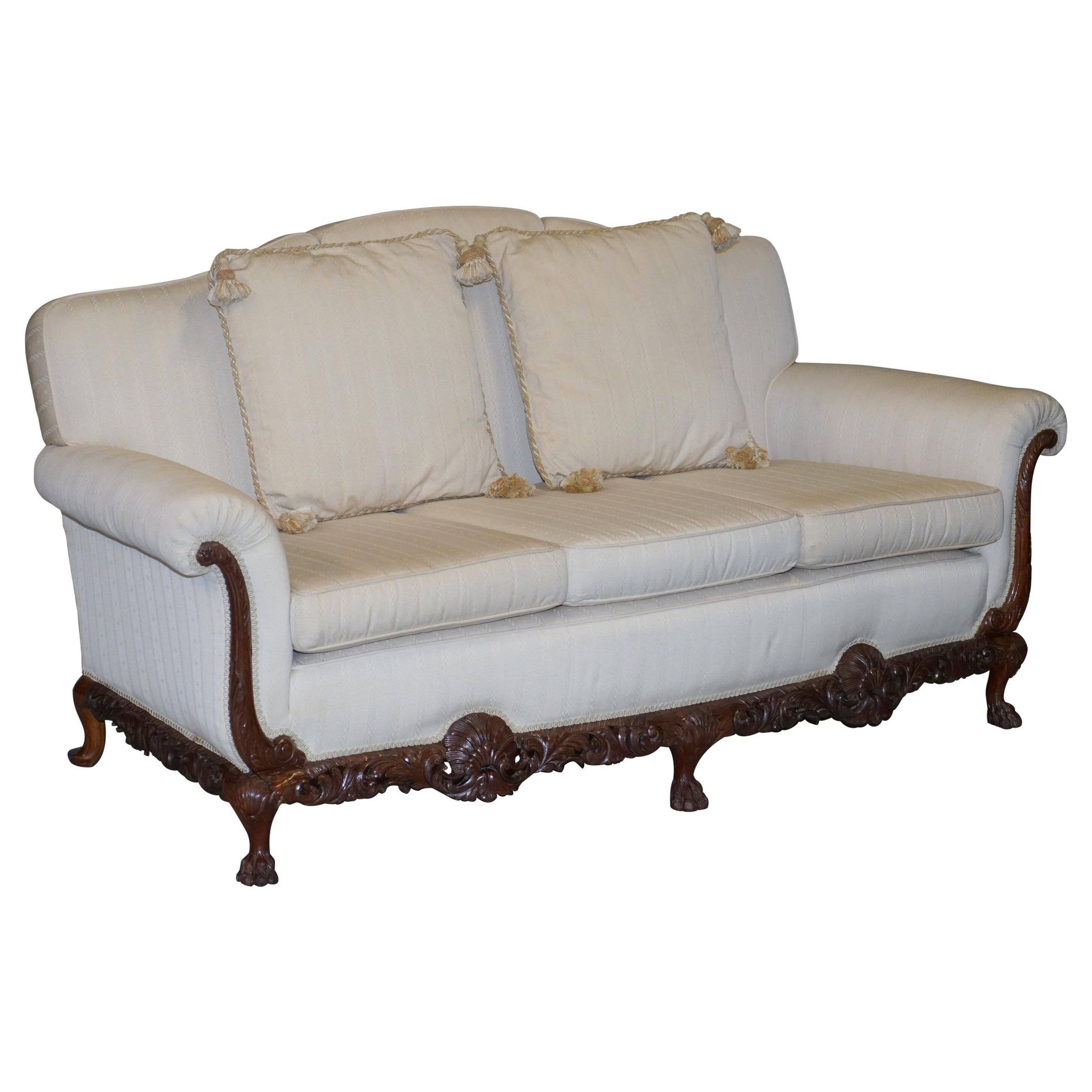 Three-seater canapé carved from solid walnut with claw feet.