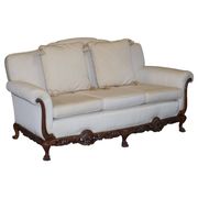Three-seater canapé carved from solid walnut with claw feet.
