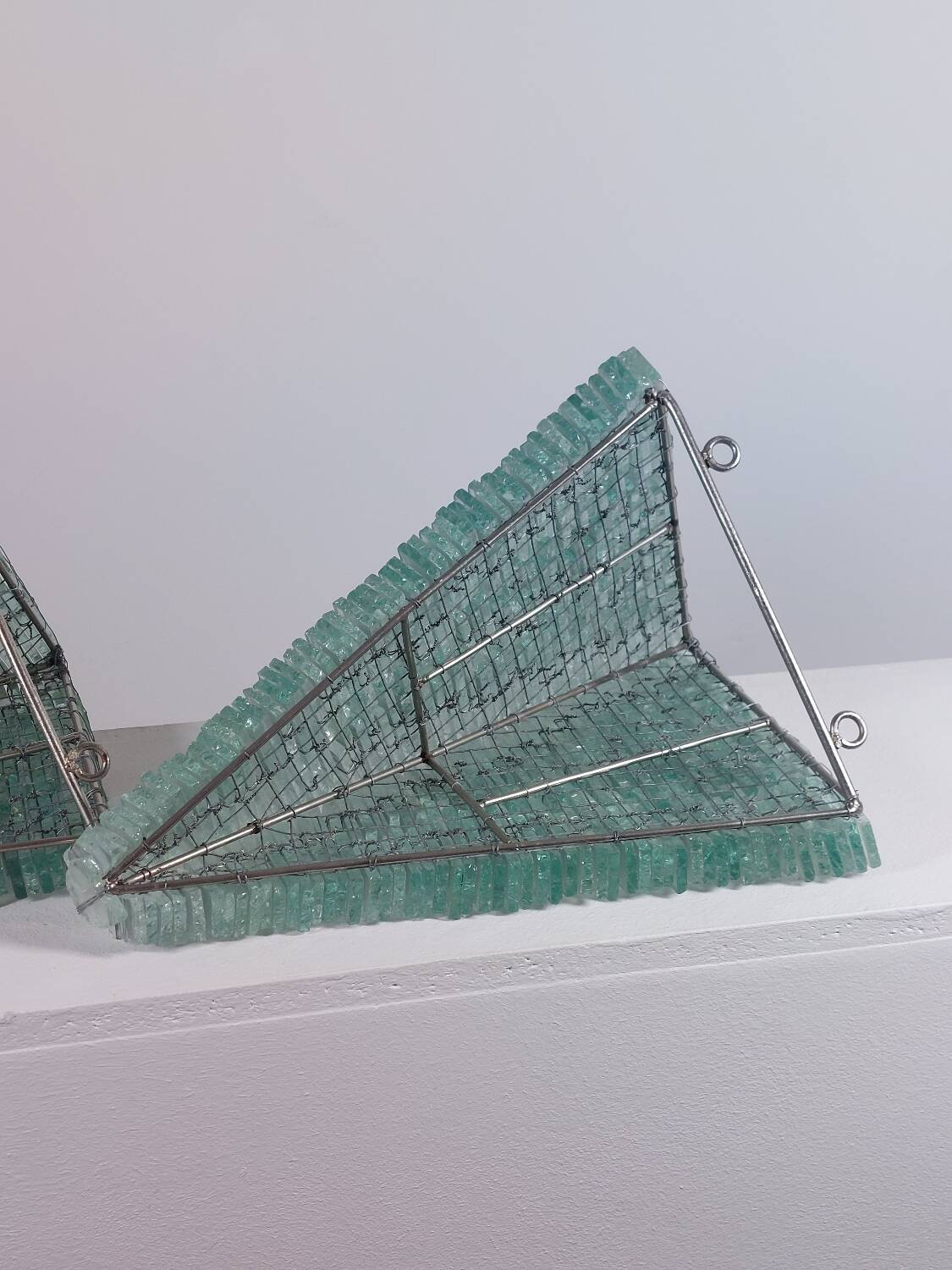 Pair of pyramid-shaped wall sconces in glass in vintage French style.