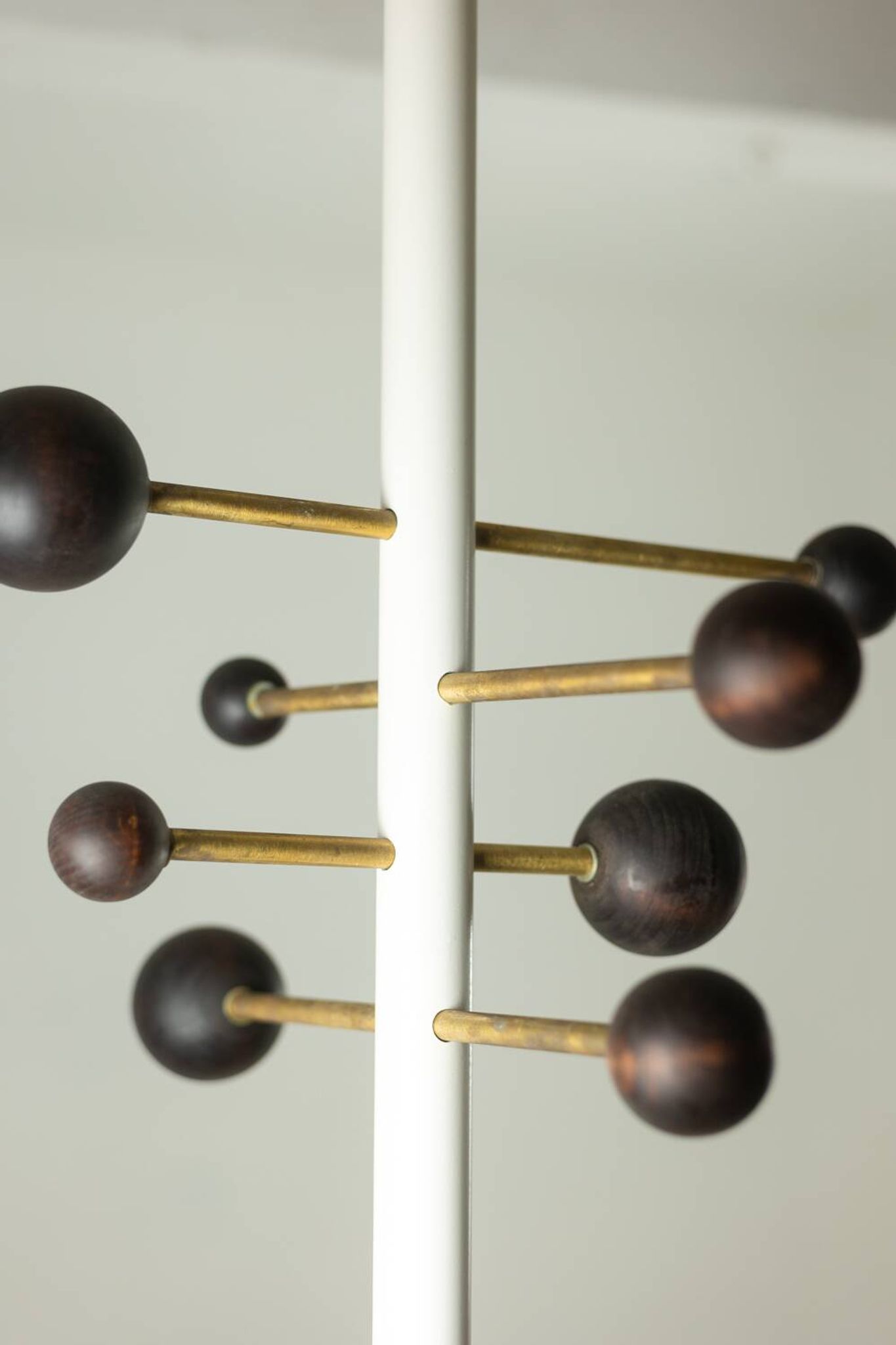 Coat rack from floor to ceiling in lacquered metal and brass. Contemporary.