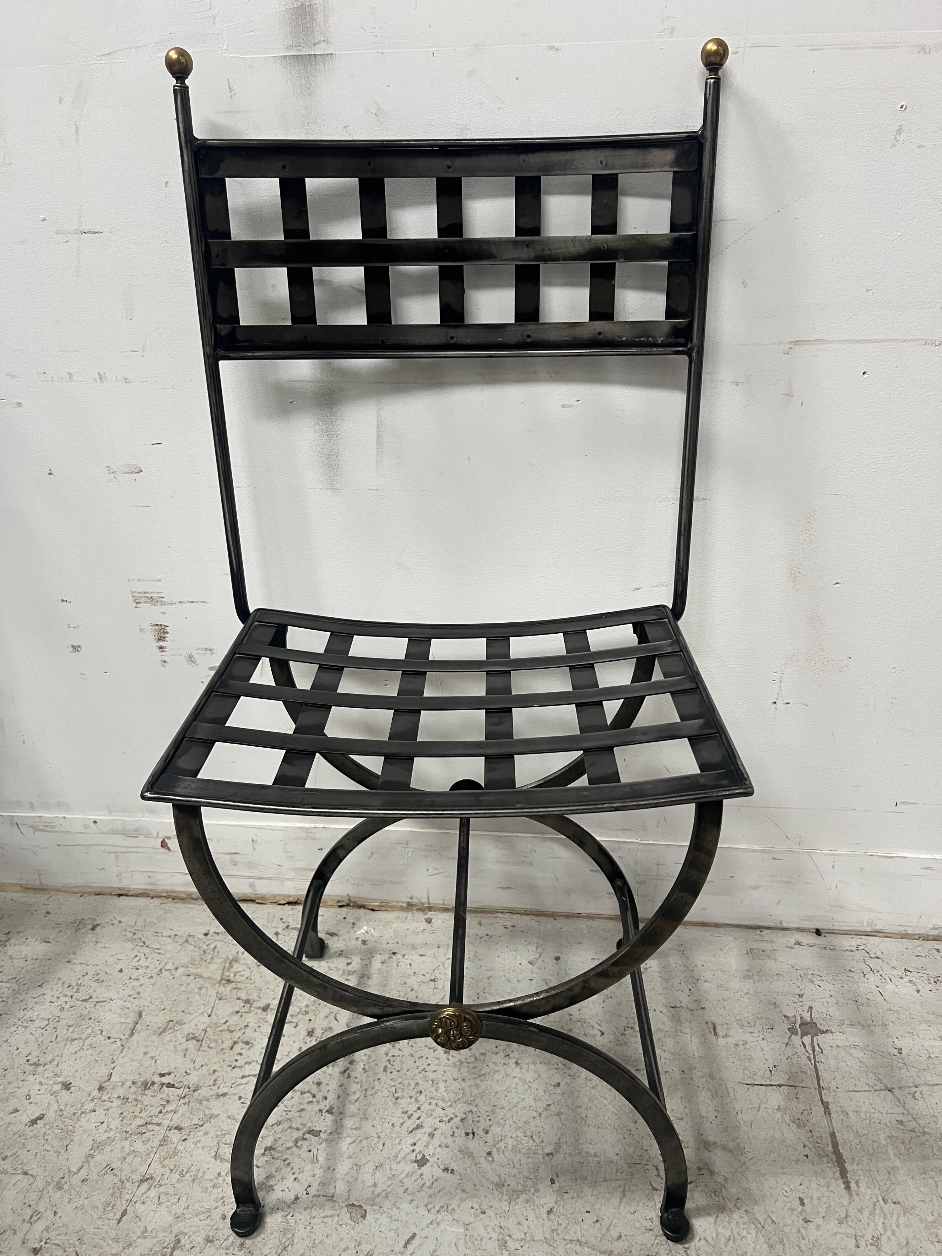 Set of four wrought iron chairs, with a reclining X-shaped base, seat and backrest.