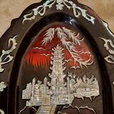 Marquetes lacquer dish with mother-of-pearl inlays figuring 3 characters on a boat in front of a temple.