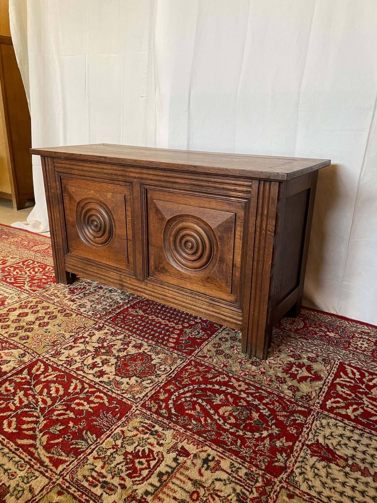 Small antique oak chest with carved panels.