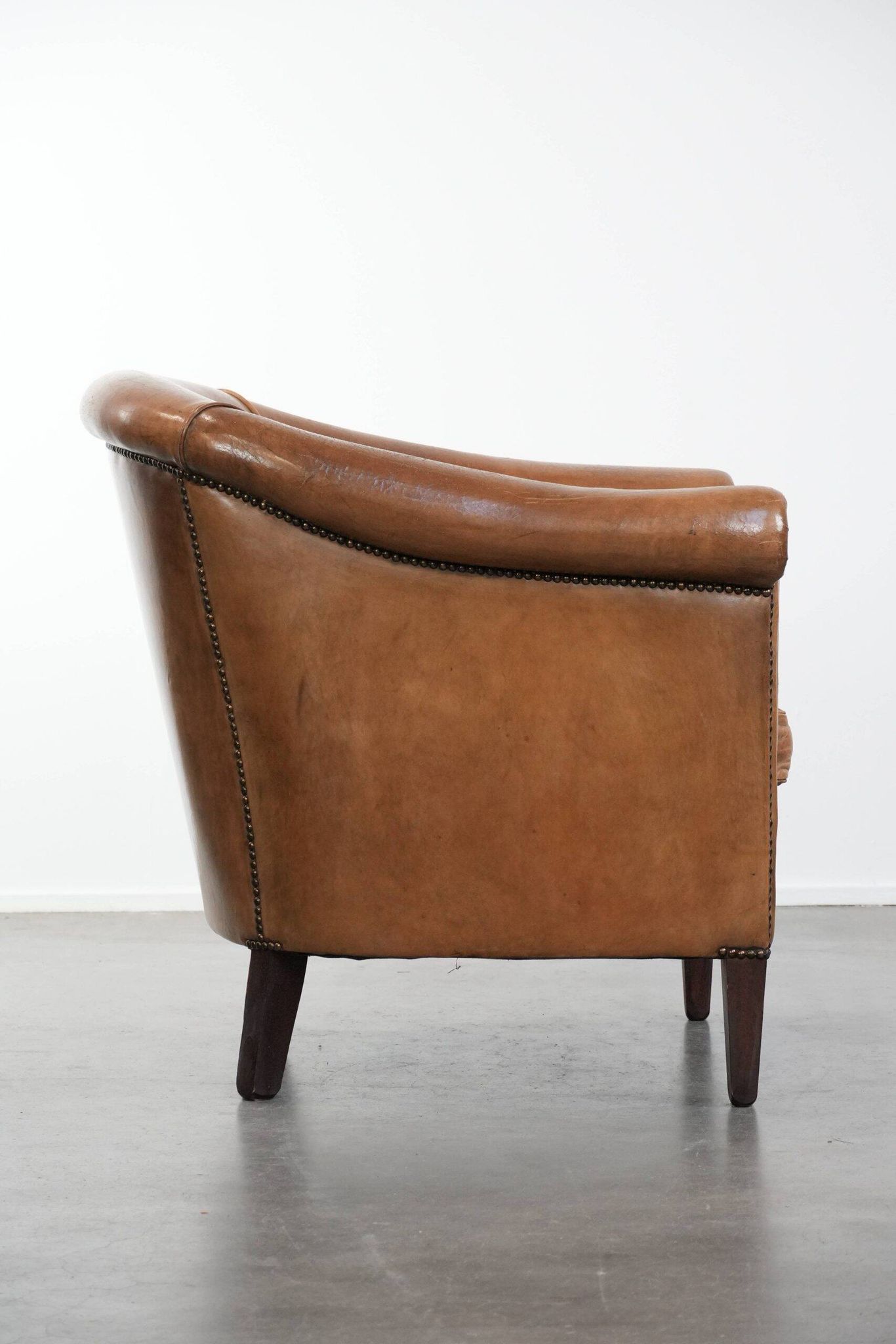 Characterful club chair made of sheepskin leather with light cognac colours