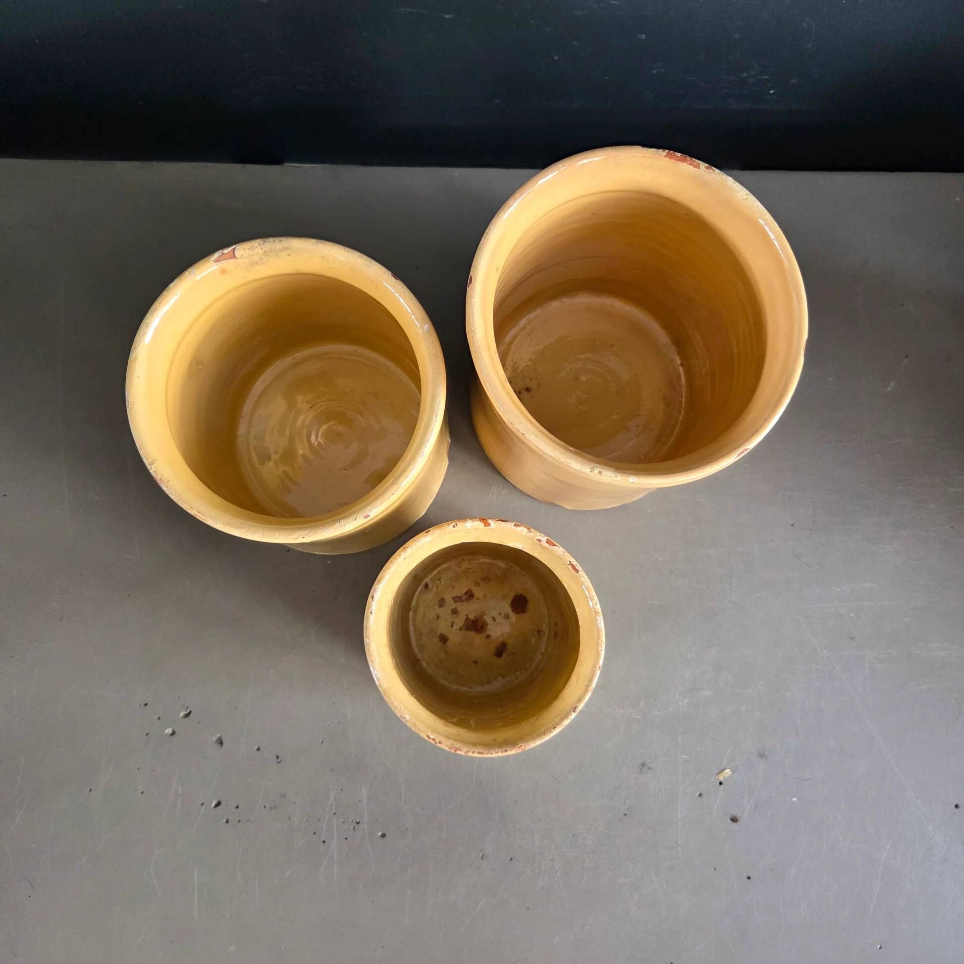 Trio of ancient pots in yellow glazed terracotta.